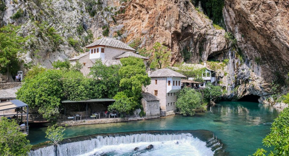 a waterfall and a building by a cliff