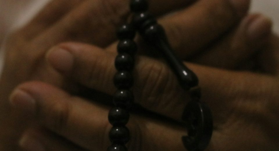 a close up of a person holding a rosary
